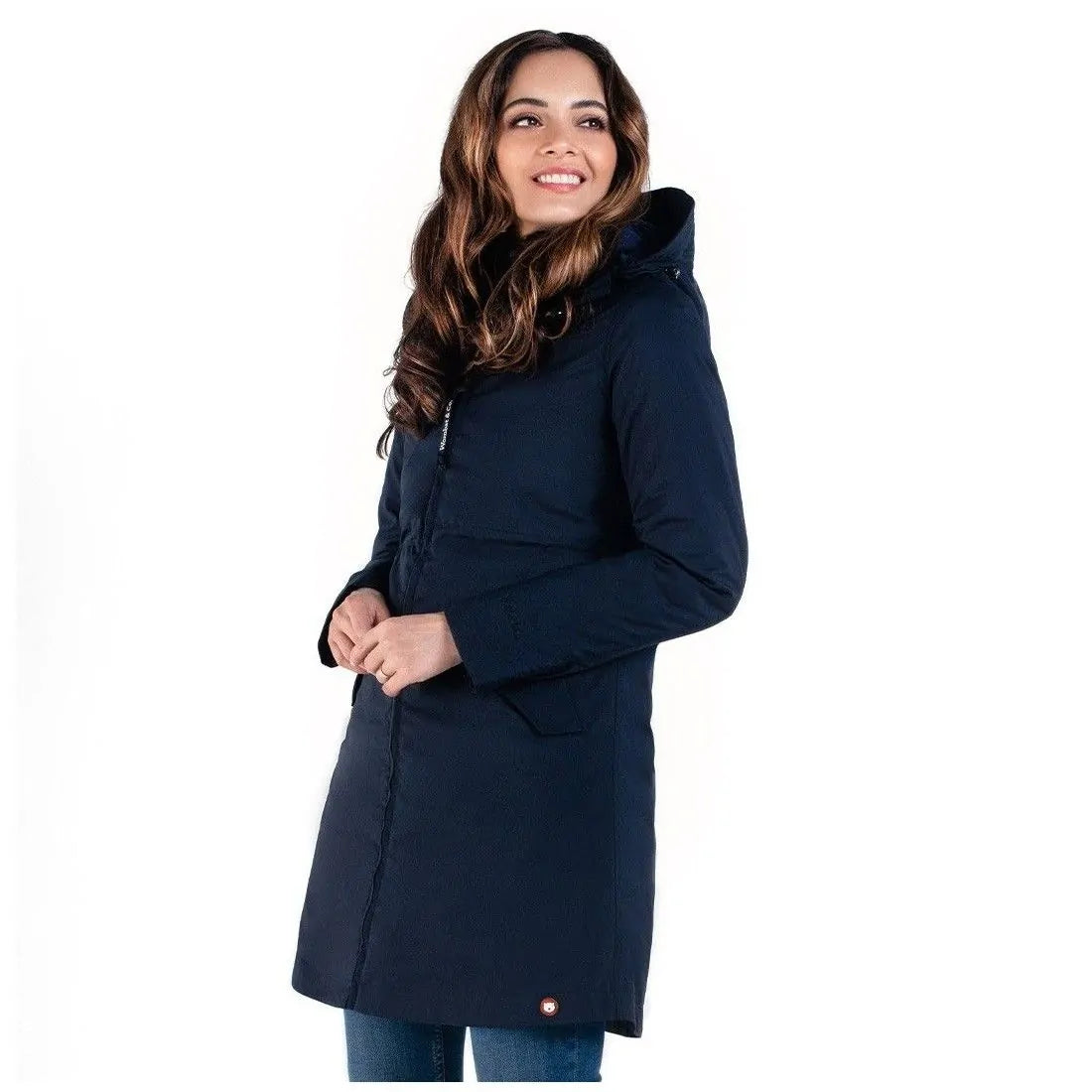Mulher sorridente a usar o casaco Wombat Kowari Marinho sem o insertável, virada de lado, mostrando o design versátil para uso diário.