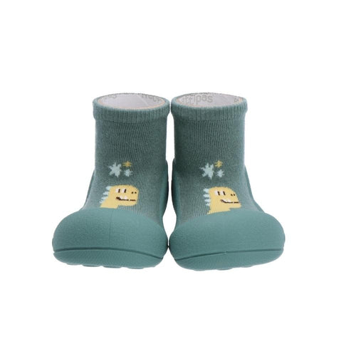 Par de sapatos Attipas DINO GREEN para bebé, com sola verde-água e parte superior verde escura com desenho de dinossauro amarelo, vistos de frente.