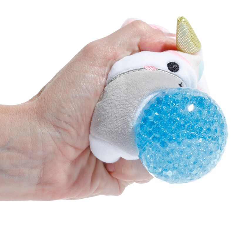A hand squeezing an Adoramals Queasy Squeezies Unicorn plush toy, highlighting the blue textured ball.