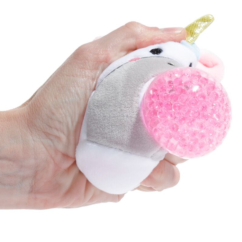 A hand squeezing an Adoramals Queasy Squeezies Unicorn plush toy, highlighting the pink textured ball.