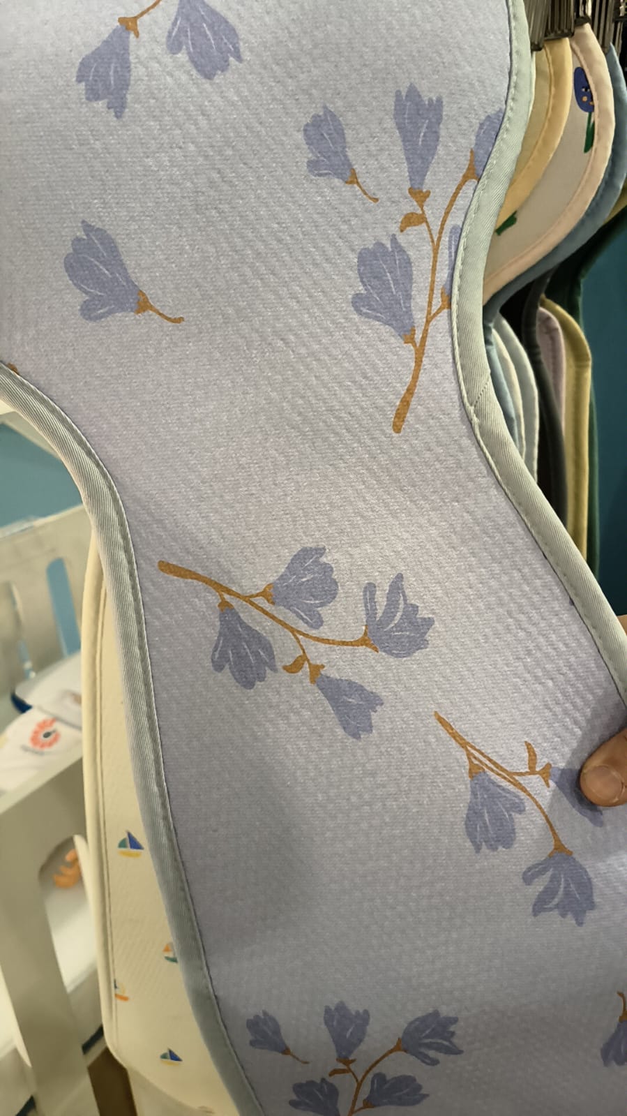 Detalhe da capa Aeromoov AirLayer 3D para Grupo 2/3 com padrão floral azul claro, mostrando a textura respirável.