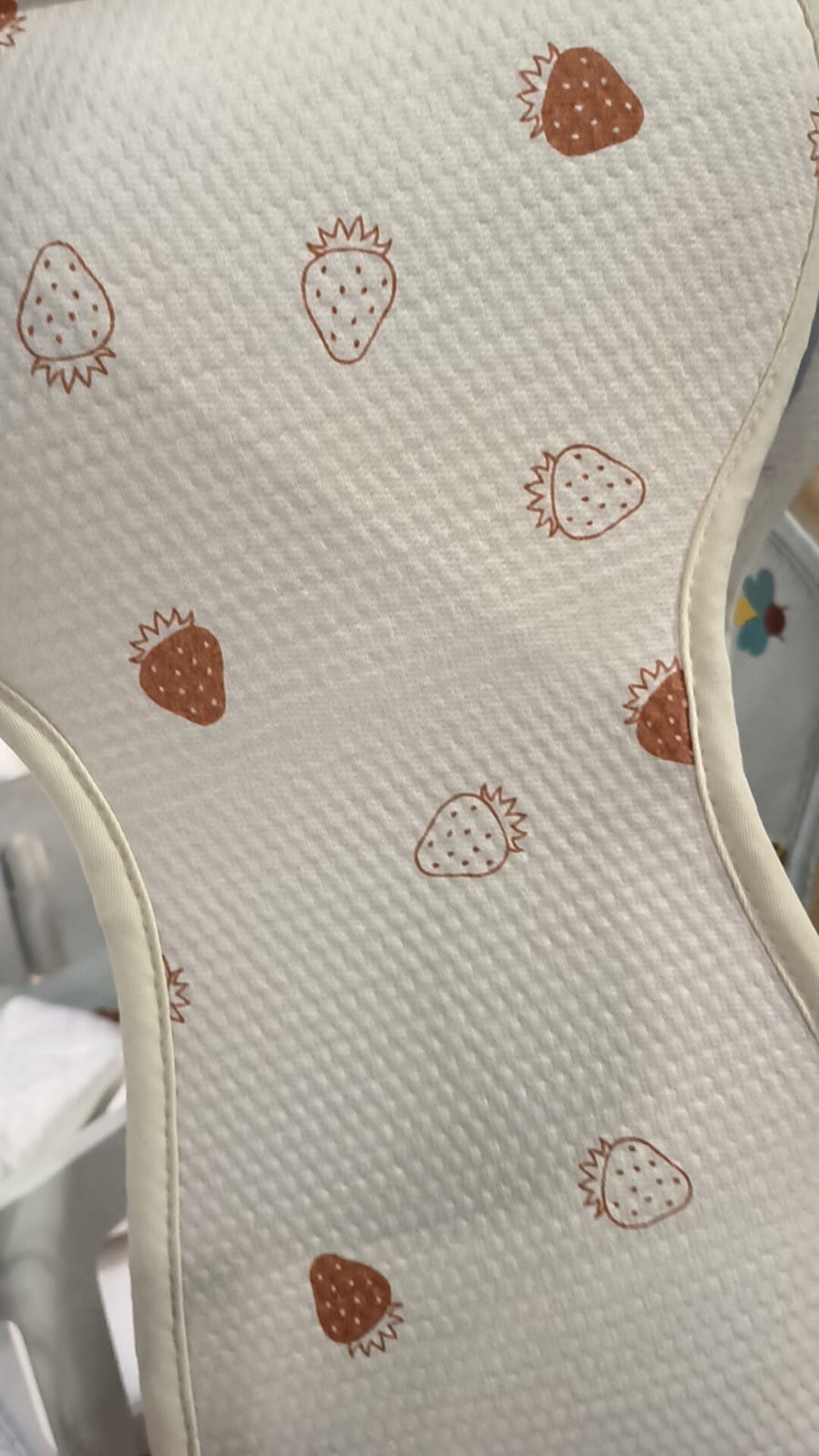 Detalhe da capa Aeromoov AirLayer 3D para Grupo 2/3 com padrão de morangos castanhos sobre fundo branco, evidenciando a tecnologia respirável.