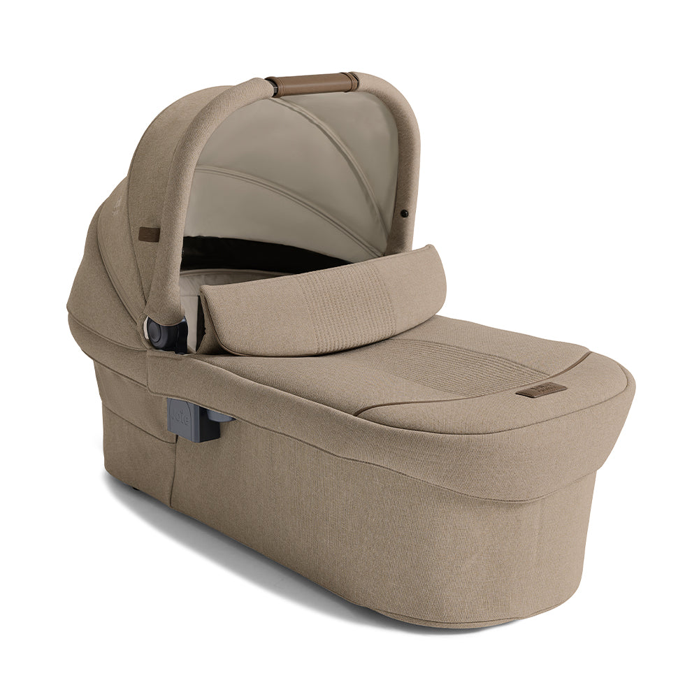 Alcofa Joie Ramble XL com capa de chuva transparente instalada, ideal para proteger o bebé do mau tempo.