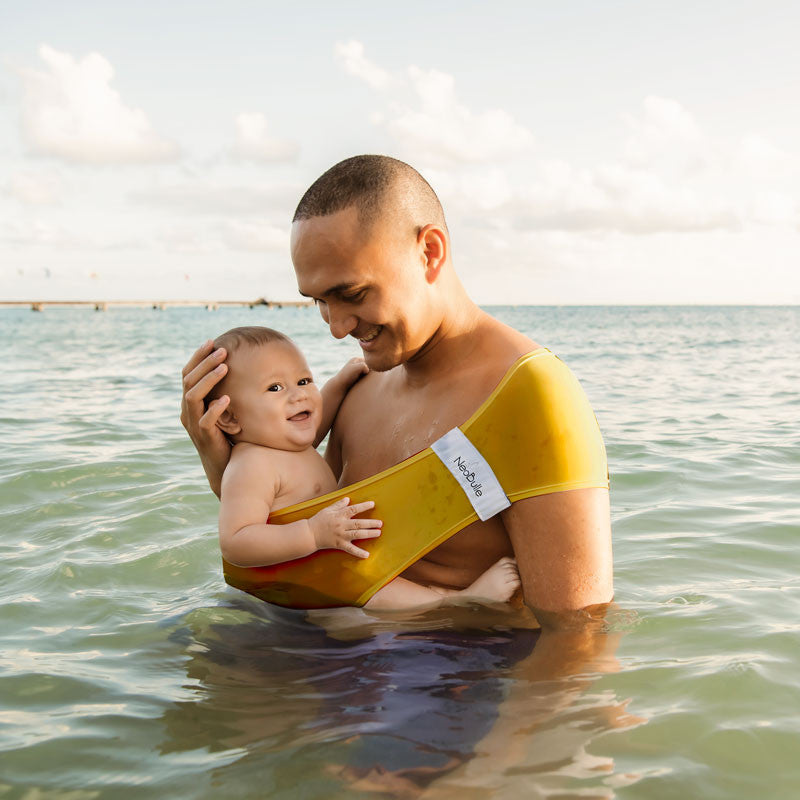 Porta-bebés Aquabulle amarelo dobrado com a etiqueta Néobulle visível.