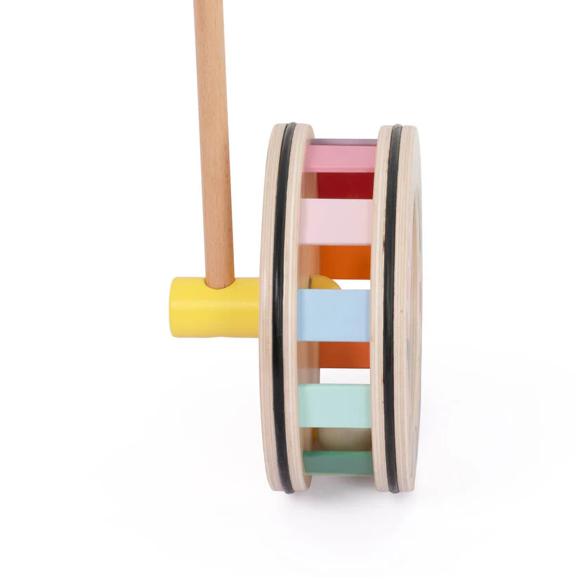 Vista lateral da roda do Classic World Rolo Arco Íris, mostrando as ripas de madeira coloridas que criam o efeito visual ao rolar.