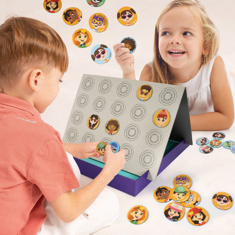 Criança e menina a jogar "Quem é quem magnético", colocando e retirando ímanes de personagens no tabuleiro dobrável.