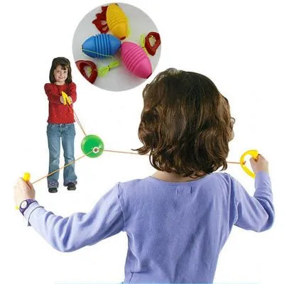 Crianças a brincar com o Jogo vai e vem da AS Company, mostrando o uso e a diversão do brinquedo ao ar livre.