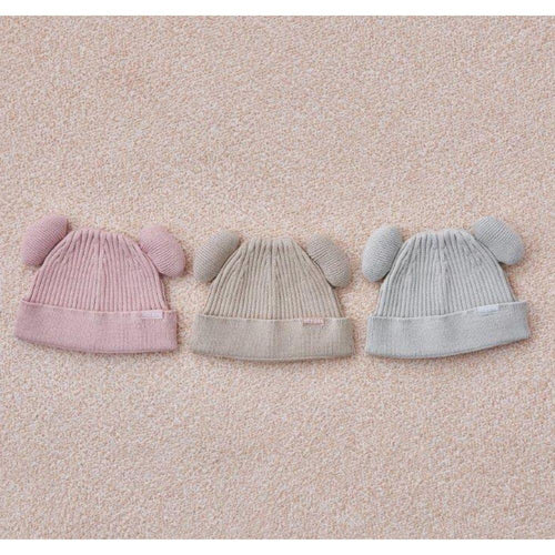 Vista superior de três gorros Attipas com orelhas (rosa, bege e cinza claro) lado a lado, exibindo o padrão de malha canelada.