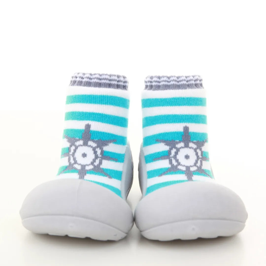 Attipas Marine Blue com riscas em azul e branco, com detalhe de leme em cinza. Calçado barefoot para bebés com sola antiderrapante.