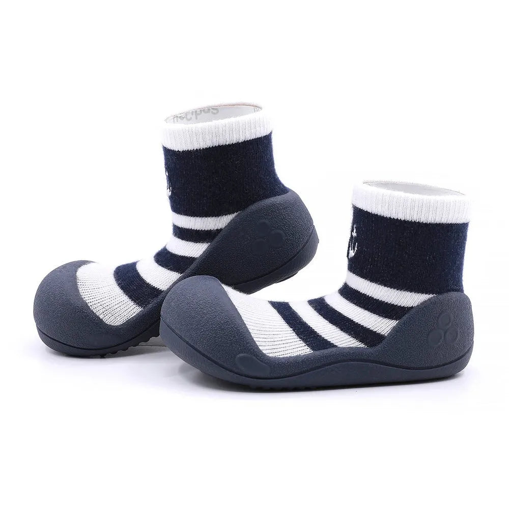 Marine Boy Navy com riscas em azul marinho e branco, detalhe de âncora bordada. Calçado barefoot para bebé com sola flexível e antiderrapante.