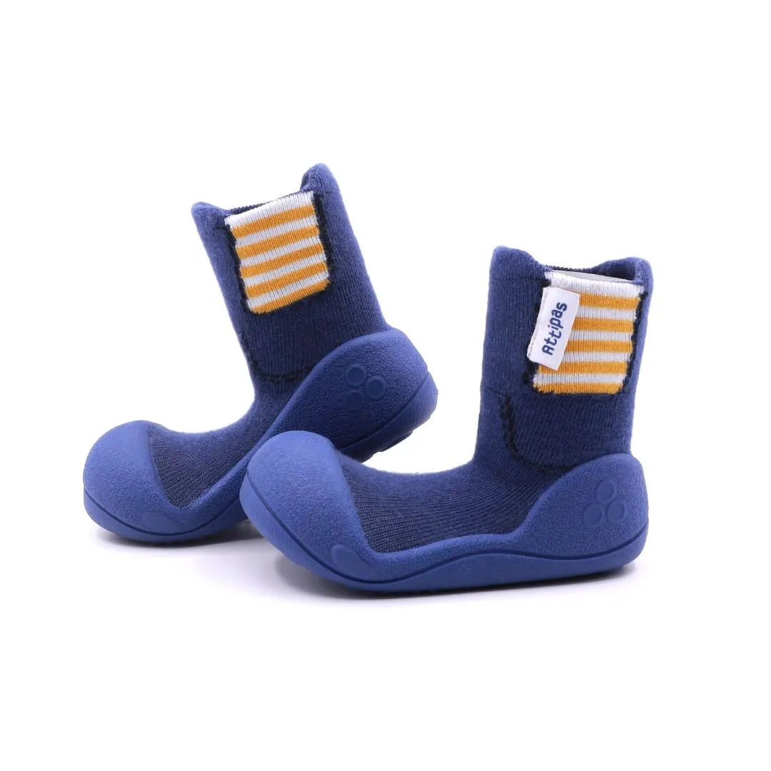  Botas Attipas Rain Boots Blue em primeiro plano, exibindo a cor azul vibrante e o design flexível, com detalhe na lateral em tecido listrado. Calçado barefoot infantil, leve e ergonômico.