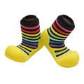 Attipas Rainbow Yellow, calçado barefoot infantil com riscas coloridas e sola amarela antiderrapante, leve, flexível e confortável para os primeiros passos.