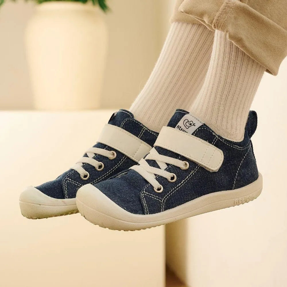 Attipas Skin Shoes Denim Azul calçados nos pés de uma criança, mostrando o ajuste confortável e o design ergonómico do calçado barefoot.