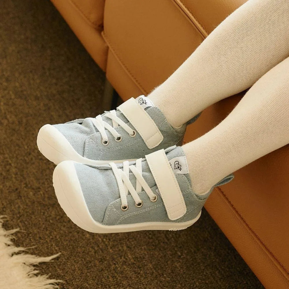 Attipas Skin Shoes Denim Light Blue calçados nos pés de uma criança, mostrando o ajuste confortável e o design leve e flexível do calçado barefoot.