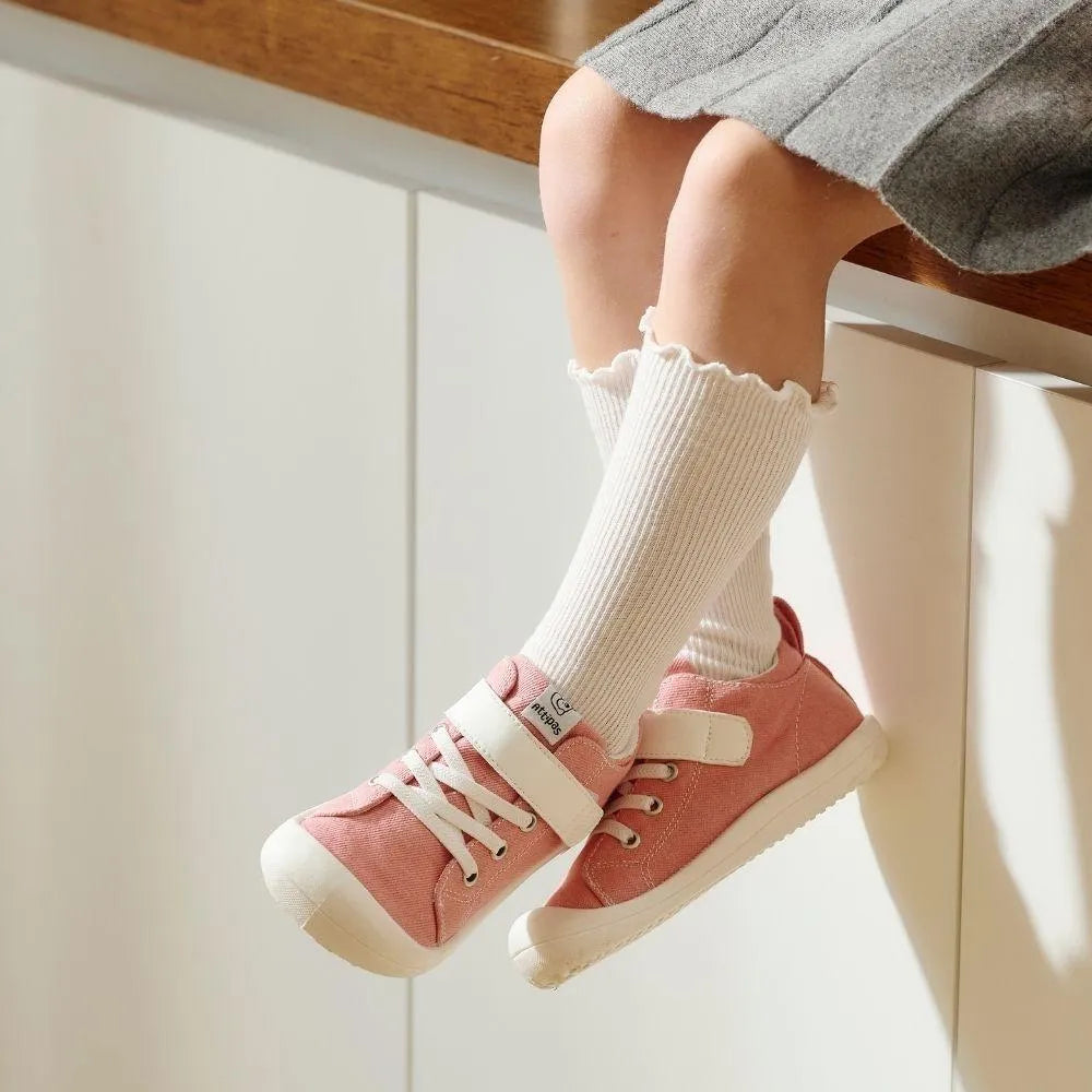 Menina sentada num balcão com os Attipas Skin Shoes Denim Pink, ilustrando o conforto e ajuste perfeito deste calçado barefoot.