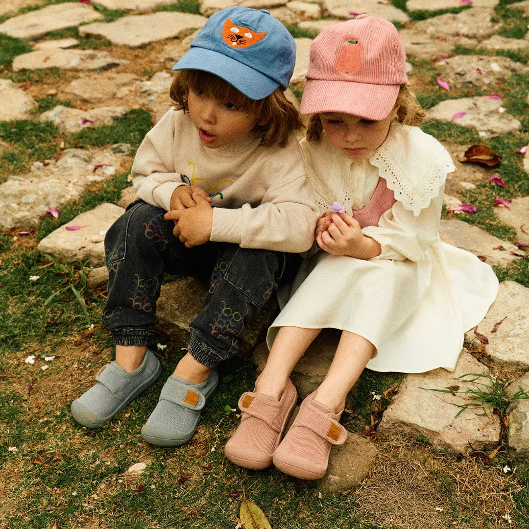 Duas crianças sentadas juntas, usando Attipas Skin Shoes (Grey), reforçando o conforto e a versatilidade para diferentes momentos do dia.
