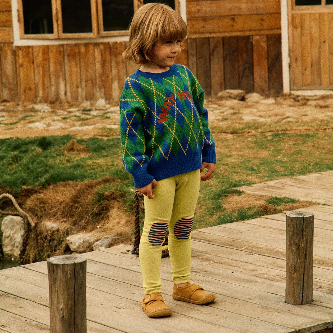 Menino em pé com Attipas Skin Shoes Mustard, explorando o ambiente com segurança e estabilidade.
