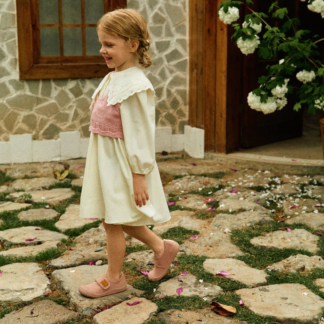 Menina em movimento usando Attipas Skin Shoes Pink, demonstrando a liberdade de exploração com o calçado flexível e seguro.
