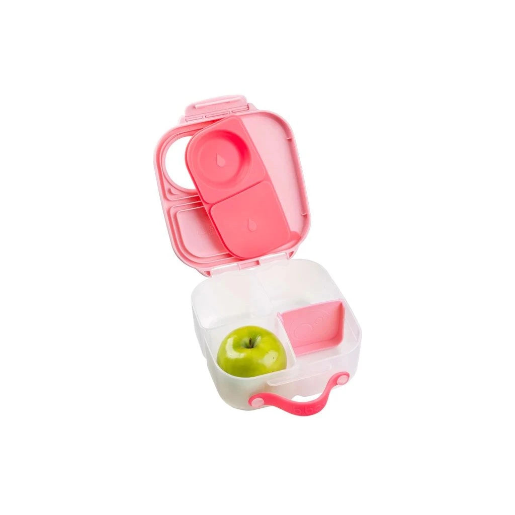Recipiente de almoço b.box mini aberto, mostrando uma maçã verde num compartimento e outros lanches, com pega rosa.