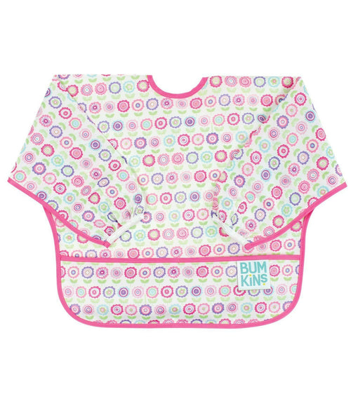 Babete Bumkins com mangas, padrão de flores coloridas em tons de rosa, roxo e verde sobre fundo branco, com acabamento a fúcsia e um bolso frontal.