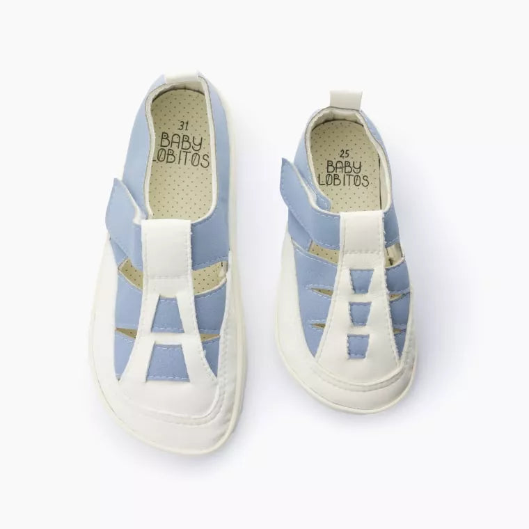 Vista superior de dois pares de sandálias romanas Baby Lobitos Ares, modelo barefoot, em azul claro e branco, mostrando o interior com a marca e o fecho de velcro.
