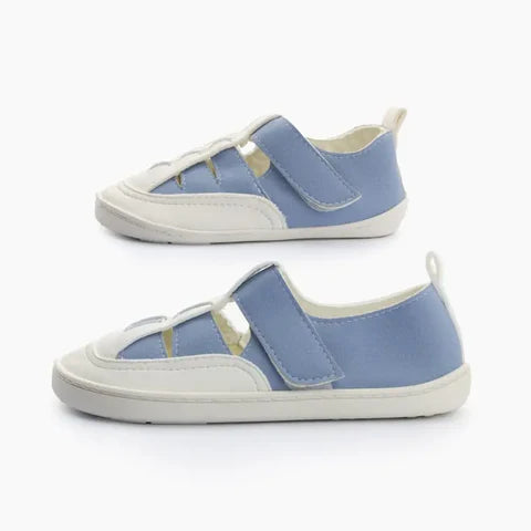 Duas sandálias romanas Baby Lobitos Ares, em azul e branco, apresentadas de perfil, destacando a sola fina e flexível e o sistema de fecho de velcro.