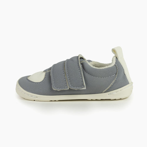 Sapatilha Baby Lobitos Barefoot cinzenta de perfil, mostrando sola fina, fecho de velcro e forro interior claro.