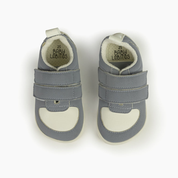 Vista superior de um par de sapatilhas Baby Lobitos cinzentas (tamanho 25) com interior branco e logótipo visível na palmilha.