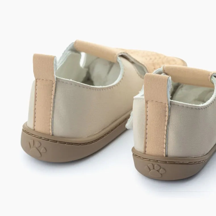 Vista traseira do Baby Lobitos Barefoot Troquelados Cream, com calcanhar em bege, puxador para facilitar o calçar e fecho em velcro ajustável.