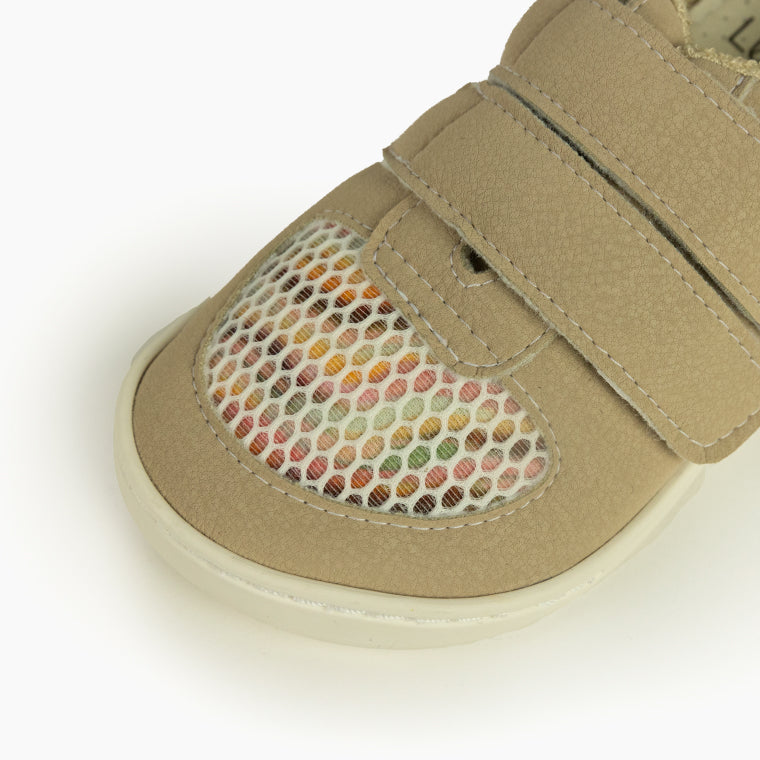 Close-up da biqueira das sapatilhas Baby Lobitos Duna, destacando a rede respirável com padrão de cores vibrantes sob o velcro.