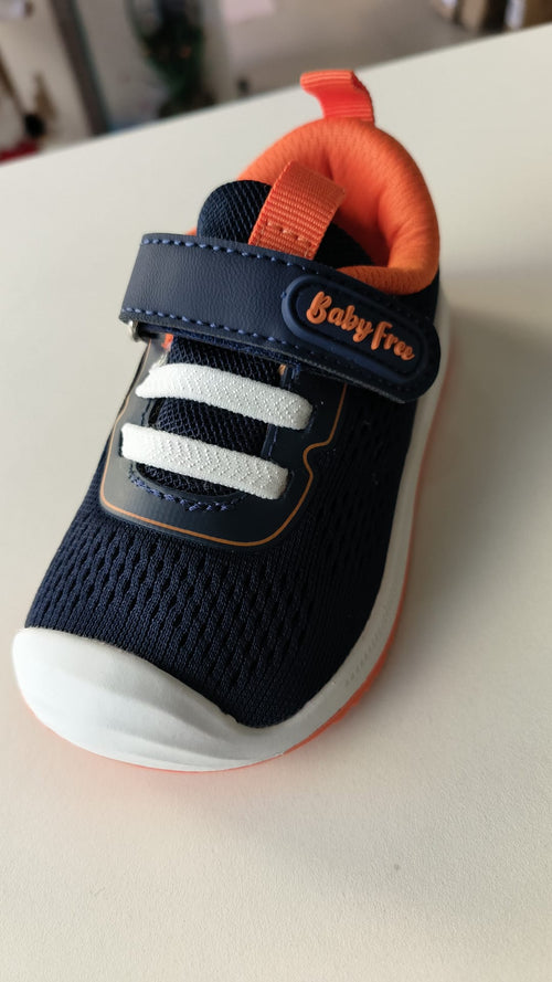 Detalhe frontal da sapatilha barefoot Chetto BabyFree azul-marinho com pormenores laranja e elásticos brancos.
