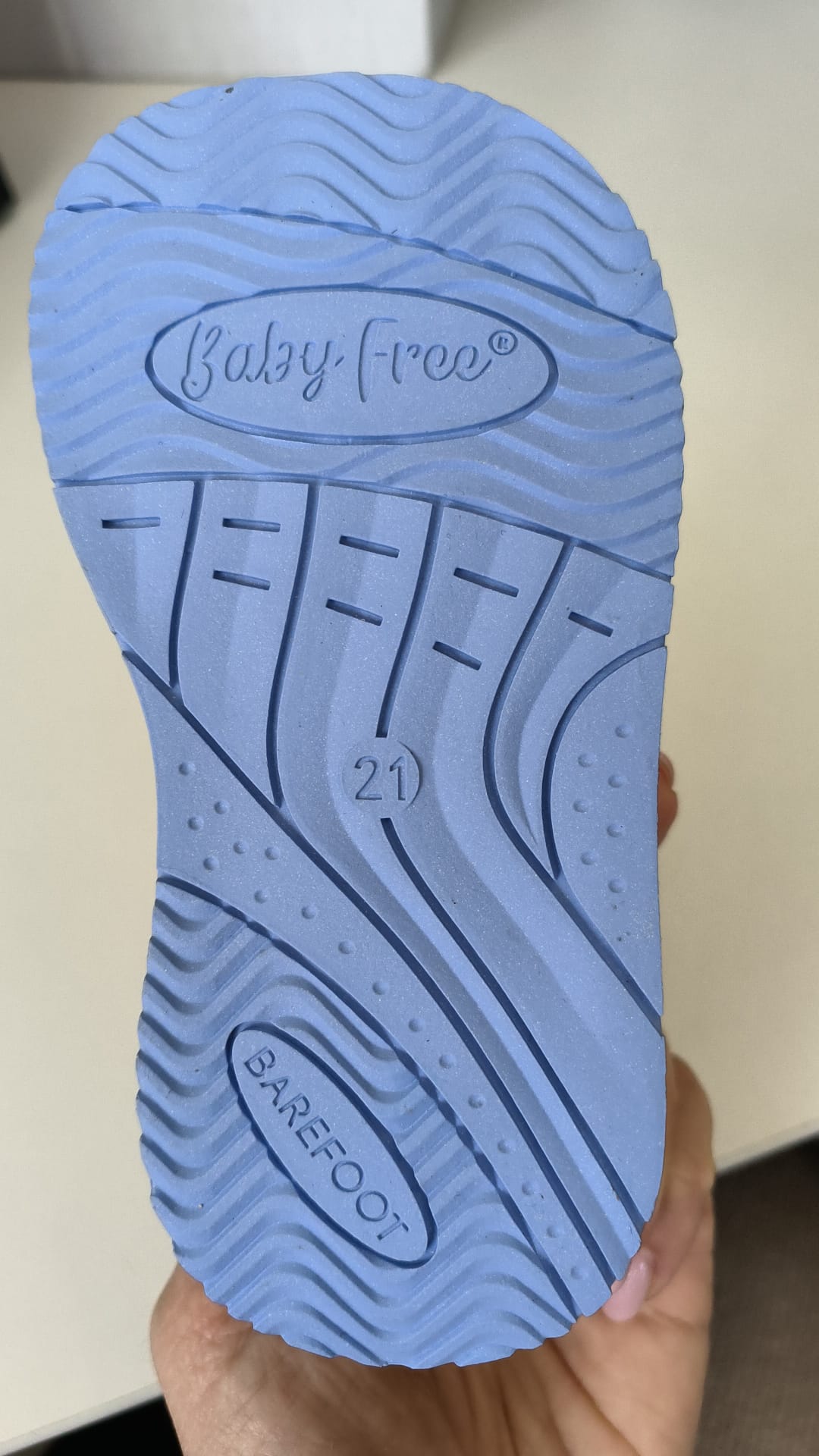 Sola azul da sapatilha BabyFree com rasto antiderrapante, indicação de tamanho "21" e inscrições "Baby-Free" e "BAREFOOT".