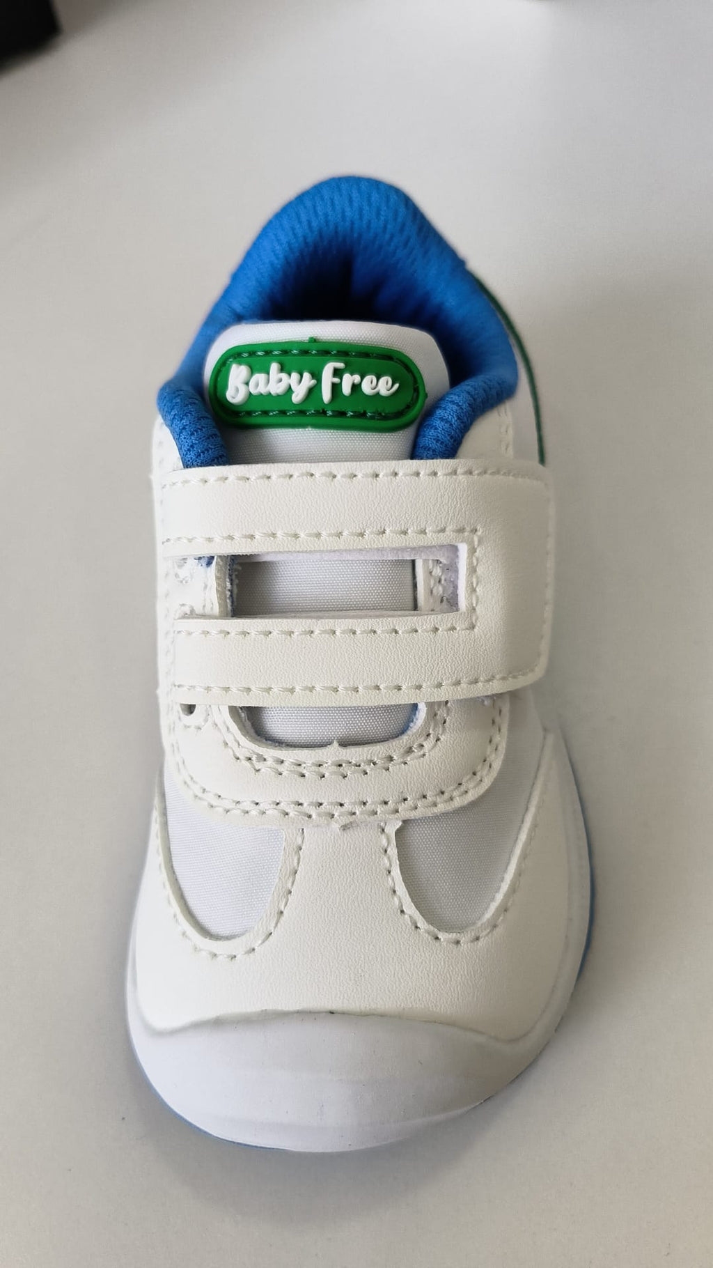 Vista frontal da sapatilha BabyFree Barefoot, evidenciando a ponteira ampla, o fecho de velcro duplo e o logótipo "Baby Free" na lingueta.