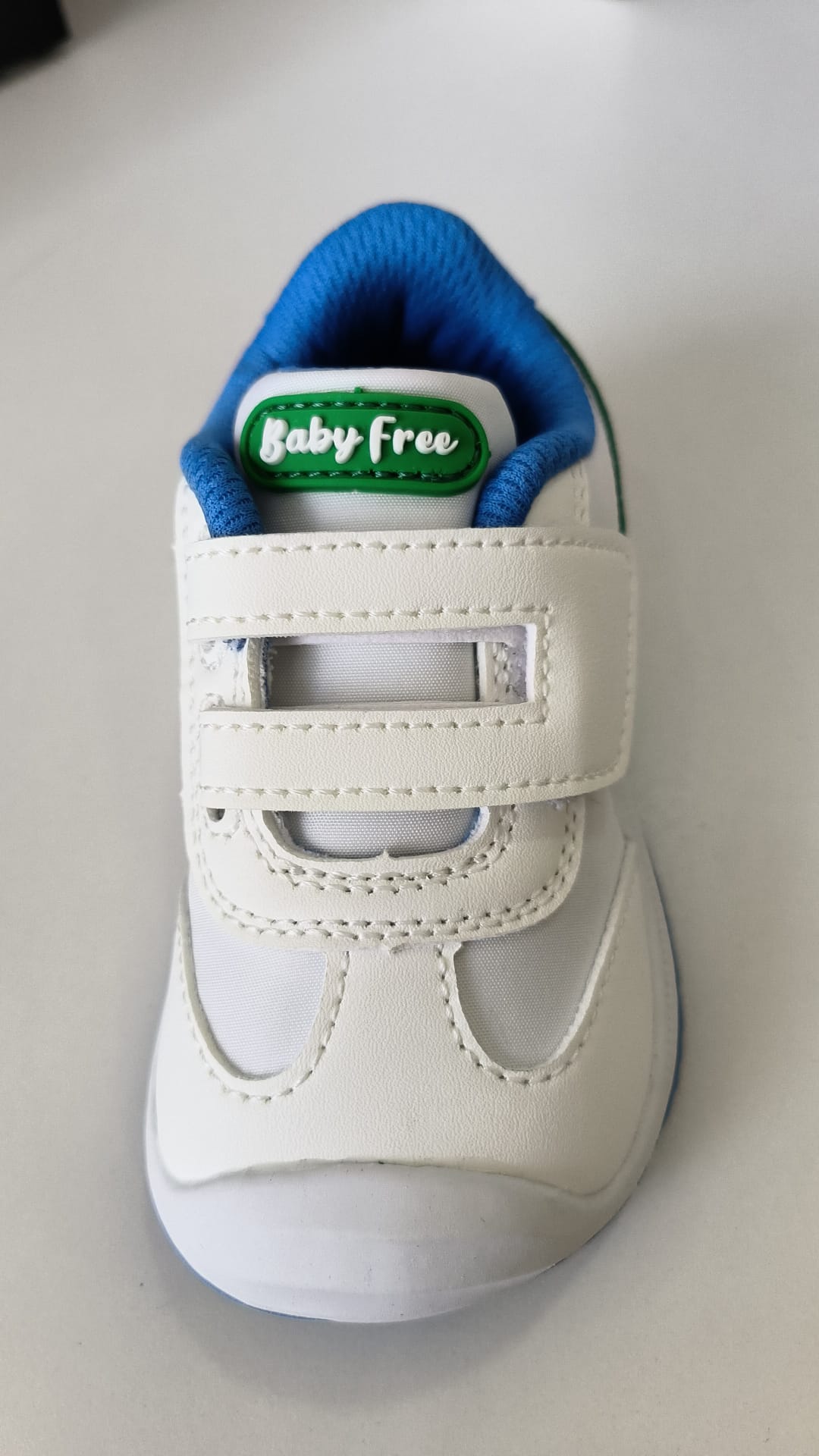 Vista frontal da sapatilha BabyFree Barefoot, evidenciando a ponteira ampla, o fecho de velcro duplo e o logótipo "Baby Free" na lingueta.