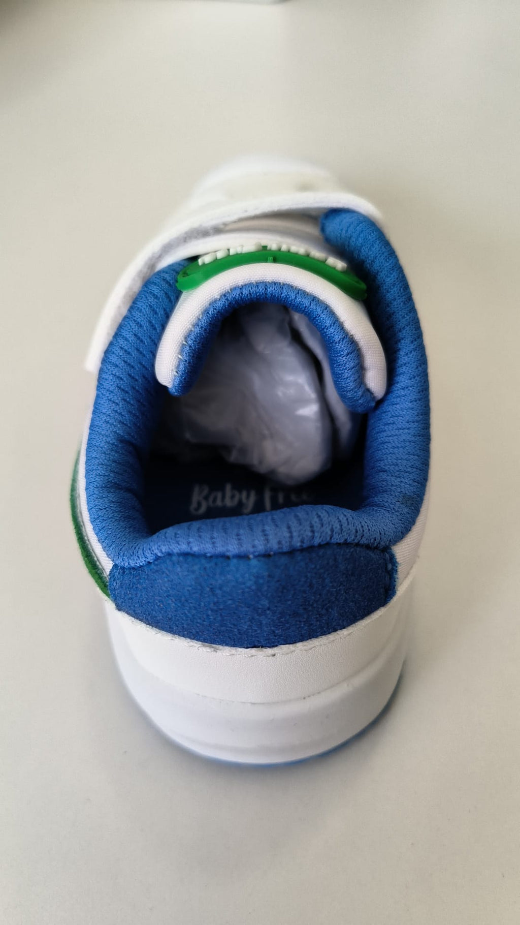 Vista traseira da sapatilha BabyFree Barefoot, destacando o interior acolchoado azul e o fecho de velcro.