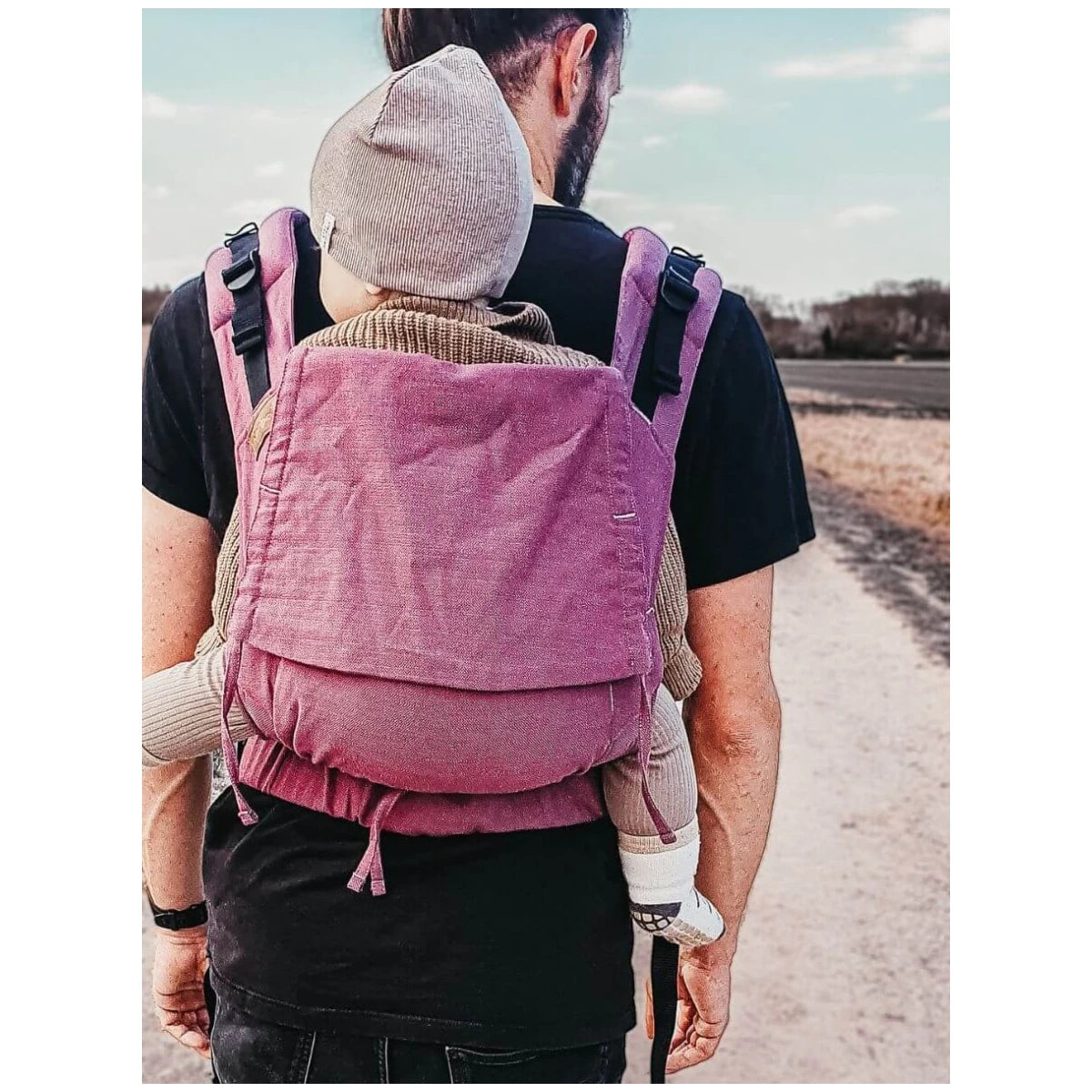 Homem a usar a Mochila Hoppediz Ajustável BabySize Buckle Mallorca nas costas, transportando um bebé.