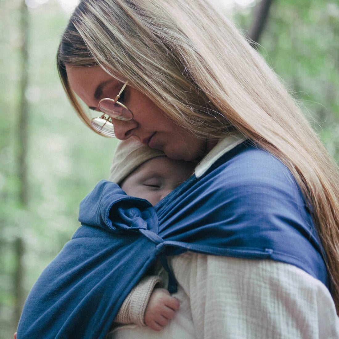 Pano elástico azul para babywearing com nó na frente, exibindo o design confortável e seguro do tecido.