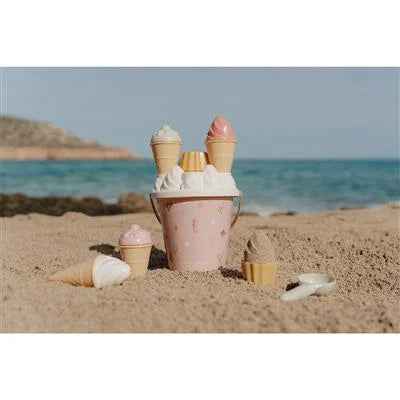 Balde de praia rosa Ocean Dreams com gelados de areia, posicionado na areia junto ao mar, com um ambiente de verão.