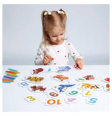 Criança pequena concentrada a montar os puzzles de números da Banana Panda numa mesa branca, interagindo com as peças e varetas de contagem.