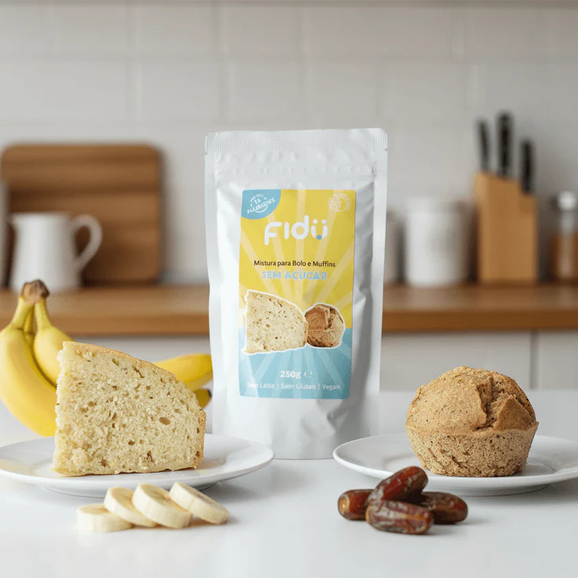 Embalagem de Fidu Preparado para Bolo e Muffins sem açúcar 250gr com fatia de bolo, muffin, banana e tâmaras numa bancada de cozinha.