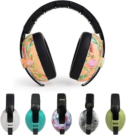Bebé a usar protetores auriculares Banz azuis com padrão, ideais para proteção contra ruído em eventos.