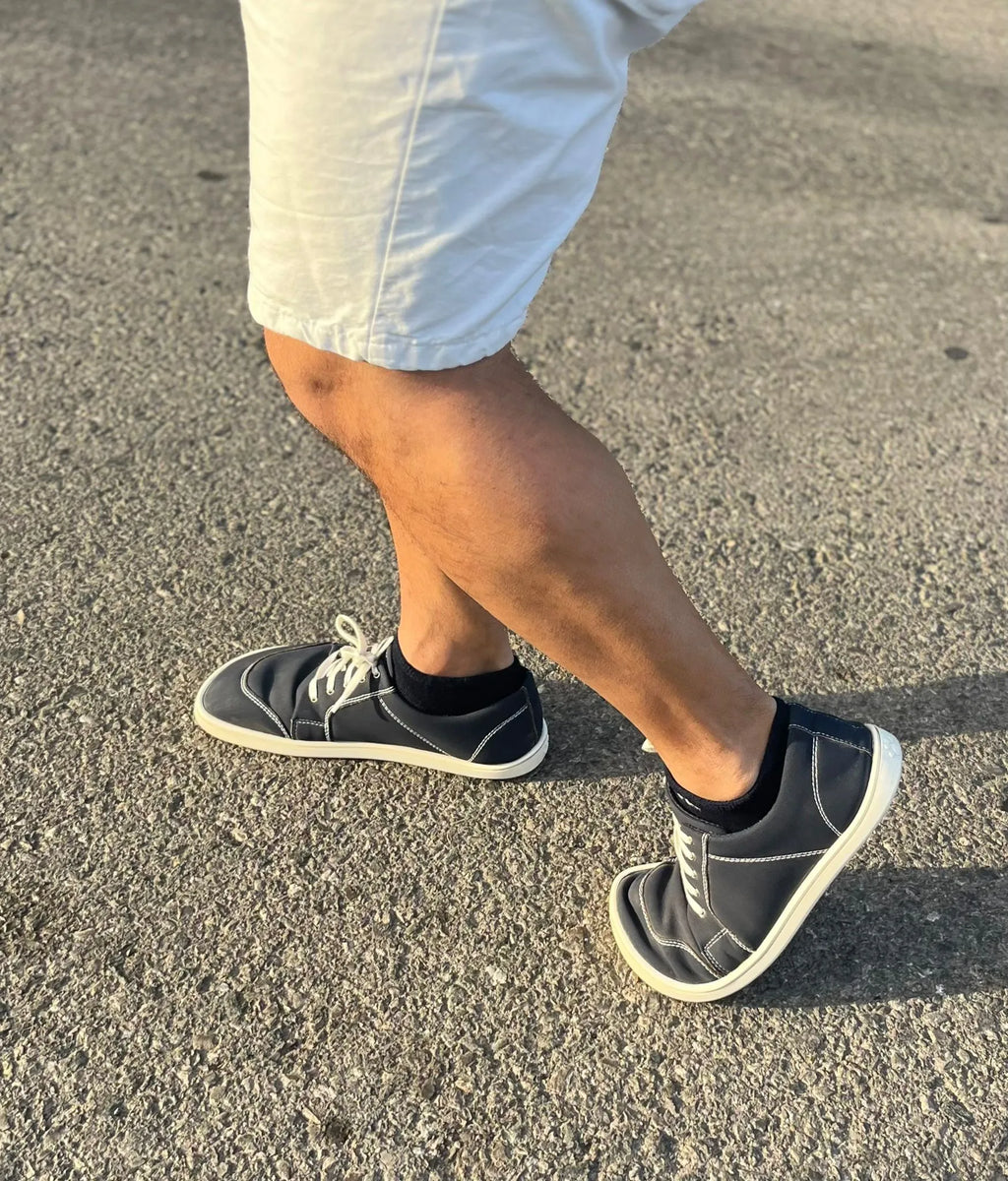 Pessoa a caminhar com o calçado barefoot adulto Mapis Noche, mostrando a flexibilidade e conforto em movimento.