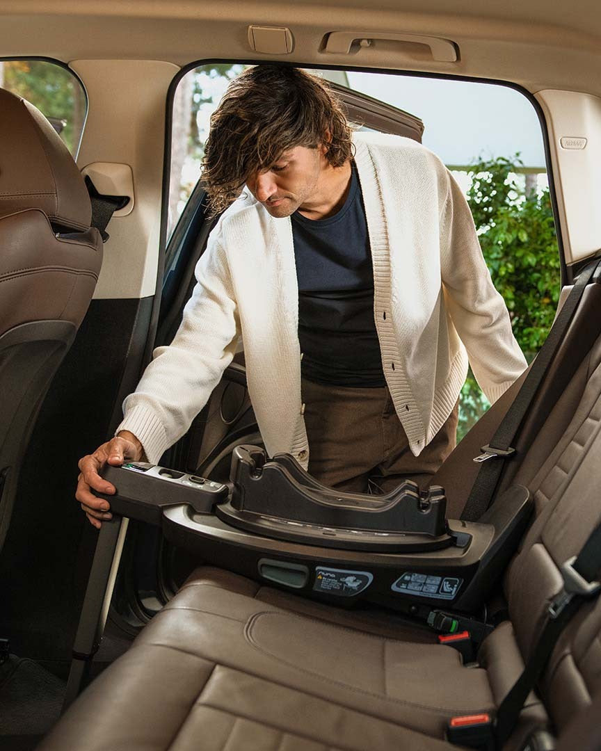 Imagem de lifestyle mostrando a Base isofix Nuna instalada num banco traseiro de automóvel, com foco na estabilidade e design compacto.