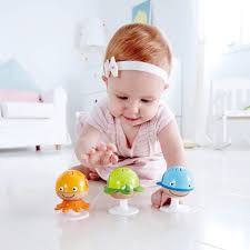 Bebé a brincar com maracas adesivas Hape fixadas no chão