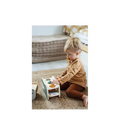 Criança pequena brincando com o jogo de martelar e xilofone small foot, focada na interação com o brinquedo.