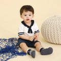 Bebé sentado usando Marine Boy Navy, calçado barefoot com riscas azul marinho e branco, design confortável e ideal para brincadeiras ao ar livre