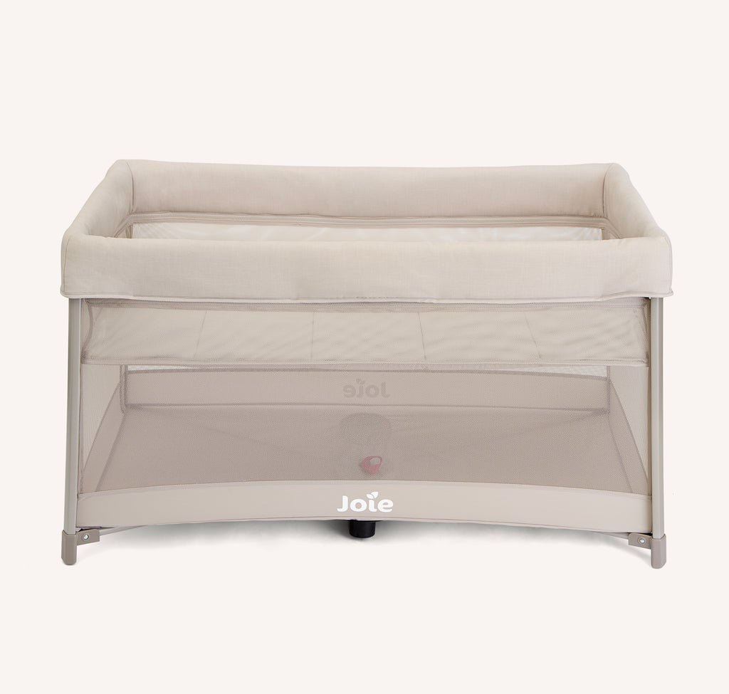 Vista frontal do berço de viagem Joie amigo™ 120 em tom bege, evidenciando a estrutura e o logótipo "Joie" na base.