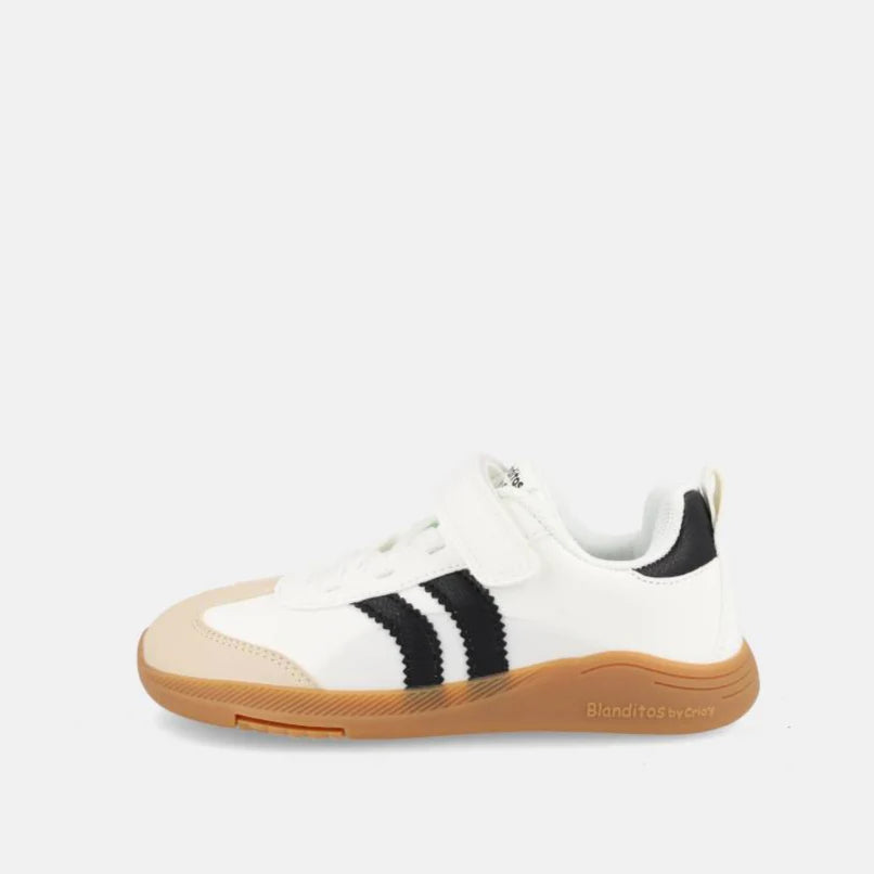 Calçado barefoot Ares vegano em microfibra branca, com riscas pretas laterais e sola de borracha castanha. Vista lateral mostrando fecho de velcro.