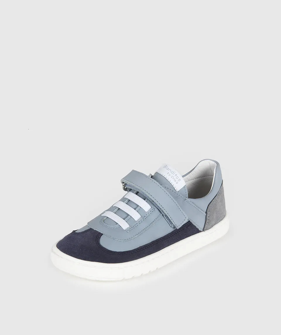 Vista lateral de sapatilha infantil Blanditos Berlin Azul em pele/camurça com sola branca e duplo velcro cinzento claro. Calçado Respeitador, Barefoot e Calçado Barefoot.