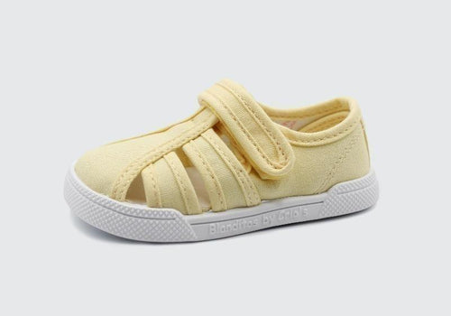 Sandália infantil barefoot Blanditos by Crio's em lona amarela clara, estilo pescador, com fecho de velcro e sola branca.